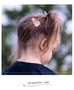 Pink rabbit hair clip with carrot detail on a child's ponytail in outdoor setting