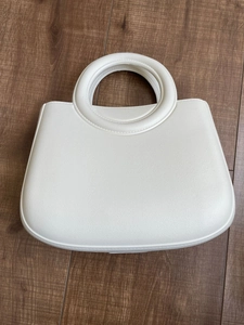 Vue de dessus du sac de plage en EVA blanc avec poignées rondes sur fond de bois rustique