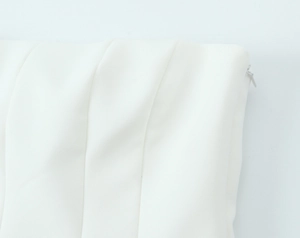 Detailed close-up of white pleated fabric and invisible side zipper on a tube top