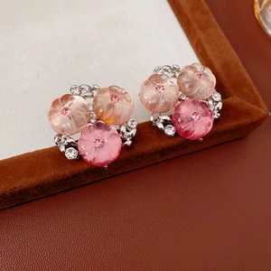 Dettaglio di orecchini a grappolo di fiori sfumati rosa su una scatola di velluto