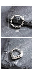 Close-up of vintage titanium steel twist ring and pentagon geometric earrings on slate