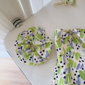 Detail of floral pleated cotton tote bag and matching scrunchie with purple dots