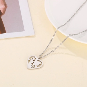 Close-up of silver hollow heart pendant with mother and child motif on a thin chain