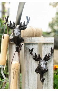 Close-up of vintage cast iron deer head hooks with rustic finish for wall hanging
