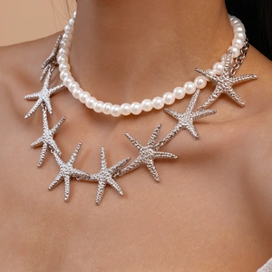 Detailed close-up of a double-layered necklace with white pearls and silver starfish charms