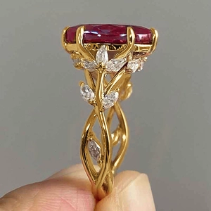 Detail of luxury vine ring with oval red gemstone and white marquise zircon accents