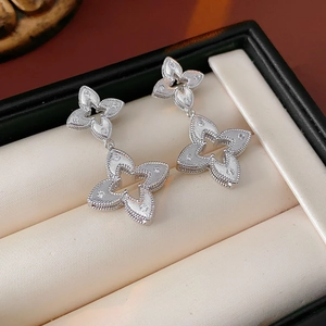 Detailed macro view of silver flower drop earrings with crystals in a luxury black jewelry box