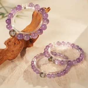 Three-layer purple amethyst bead bracelet set with silver heart charm on marble surface