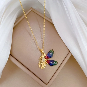 Gold titanium bee necklace with colorful enamel wings on white silk and jewelry box