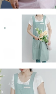 Detail of mint green linen-style apron showing wide shoulder straps and silk fabric texture