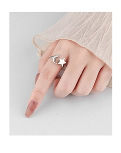 Detailed close-up of a rotating silver star and moon ring on a finger