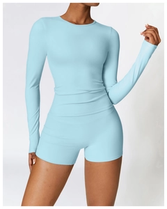 Detail of high-stretch light blue long sleeve yoga top and high waist sports shorts