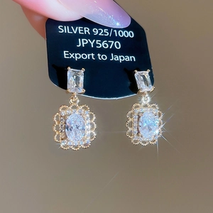 Vue macro de boucle d'oreille fleur en argent 925 avec zircons et finition dorée chic