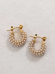 Close-up of 18K gold-plated U-shaped earrings with rows of inlaid small pearls