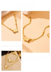 Macro detail of gold butterfly jewelry set featuring layered chains and brushed texture