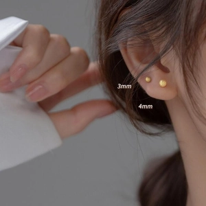 Minimalist matte gold bead stud earrings in 3mm and 4mm sizes worn by model