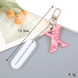 Pink marble texture resin letter X keychain with silver spring clasp and motto tag
