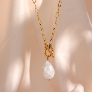 Detail of baroque pearl pendant on gold stainless steel oval link chain with OT clasp