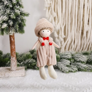 Knitted hat overalls Christmas doll ornament hanging on a festive holiday tree branch