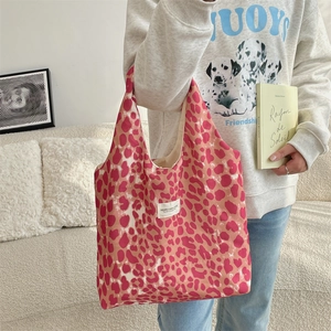 Detail of pink leopard print canvas tote bag with woven SUZAKKA logo label