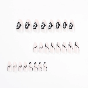 Almond press-on nails with black white flower patterns and rhinestones on white background