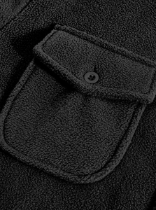 Detail of soft black fleece jacket featuring a flap pocket and round button closure