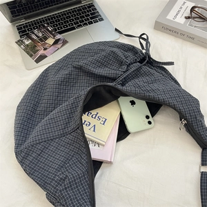 Spacious grey checkered nylon tote bag showing interior storage for books and a smartphone