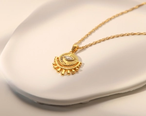 Detailed macro of gold sun eye pendant with marquise-cut zircon on o-chain necklace