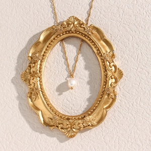 Elegante collana a catena dorata con perla d'acqua dolce bianca su cornice vintage