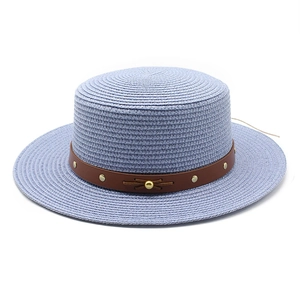 Détail du chapeau de paille bleu avec ruban en cuir marron et ornements de clous dorés
