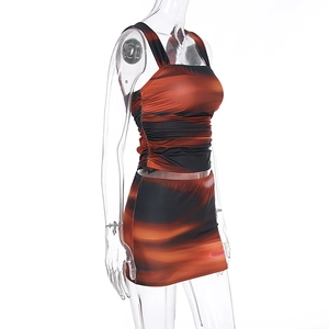 Detail view of side ruching on orange and black marble print crop top and mini skirt