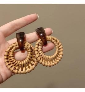 Macro shot showing the texture of woven rattan drop earrings with resin wood accents