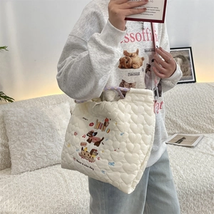 Detail of off-white quilted tote bag featuring a cute cartoon dog and heart stitching