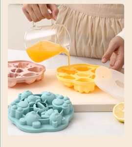 Close-up of pastel silicone baby food mold showing cat paw shapes with lids