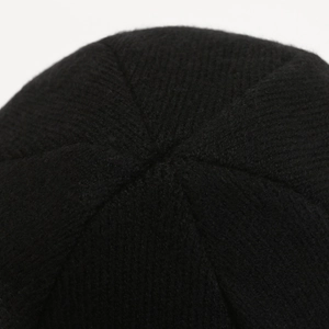 Close-up of top stitching on a black winter knit beanie made of warm thermal wool