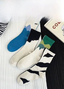 Detail of trendy cotton crew socks featuring mountain prints and zebra stripe patterns