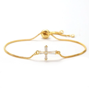 Detail of adjustable golden box chain bracelet featuring a zircon-inlaid cross pendant