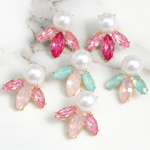 Detailed view of luxury pearl and marquise crystal earrings on white marble surface