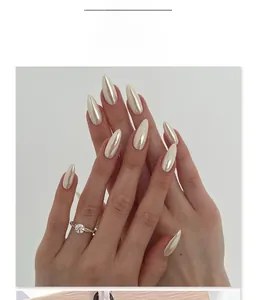 Macro view of almond shaped champagne pearl chrome nails with glossy metallic finish