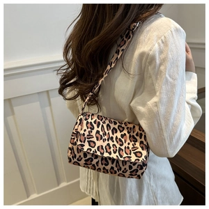 Detailed view of leopard print shoulder bag worn by model in a modern lifestyle setting