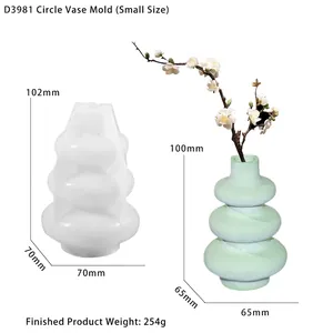 Dettaglio stampo in silicone per vaso circolare con vaso rifinito in verde e rami decorativi