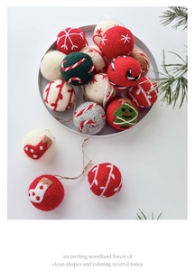 Detailed close-up of handmade wool felt Christmas balls with festive patterns and jute hangers