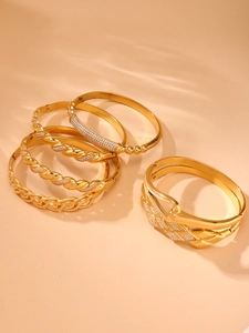 Dettaglio di bracciali in acciaio placcato oro 18k con fibbie a ferro di cavallo e zirconi