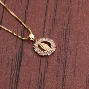 Macro shot of gold plated pendant with micro-pave zircons and religious relief detail