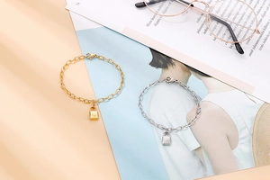 Detailed view of gold and silver padlock bracelets on a stylish magazine background