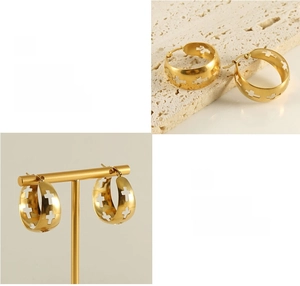 Macro detail of gold-plated hollow cross hoop earrings with polished finish on display