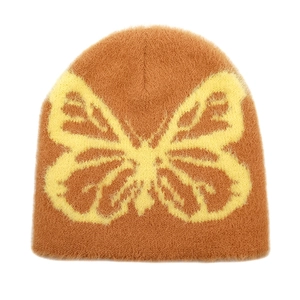 Detail of plush butterfly jacquard texture on warm brown winter knit beanie hat