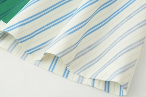 Close-up of blue vertical stripes on white cotton fabric with fine stitching details