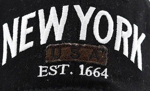 Close-up of New York embroidery and USA patch on black cotton baseball cap