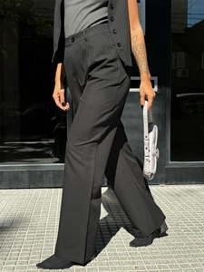 Chic black high-waisted wide-leg trousers and matching suit vest in urban street style